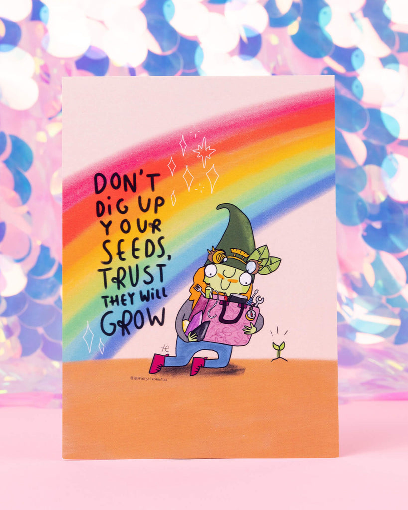 Colourful Virgo themed postcard by Happiness Enchanters, available at Rebel Romance. Features a green-hatted gnome planting a tiny sprout under a rainbow with the words “Don’t dig up your seeds, trust they will grow.” Illustrated by Katie Abey. Perfect for astrology lovers and gift givers who adore earthy, magical vibes.