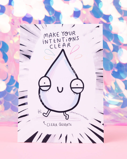 Postcard illustrated by Katie Abey for Happiness Enchanters, featuring a cute clear quartz crystal character with the phrase “Make Your Intentions Clear.” The background is a soft explosion of monochrome lines radiating out from the centre. Sold by Rebel Romance, a UK brand for alternative fashion and quirky gifts.