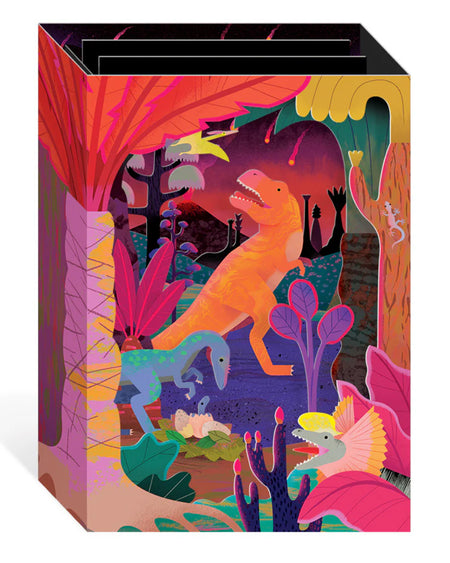 A vibrant 3D pop-up greeting card from Rebel Romance featuring colourful carnivorous dinosaurs in a prehistoric jungle. Designed by Natasha Durley, this laser-cut card includes a bright orange T-Rex, blue raptor, and other neon dinos surrounded by tropical plants and a volcanic sky. Ideal for dinosaur lovers and alternative card collectors.