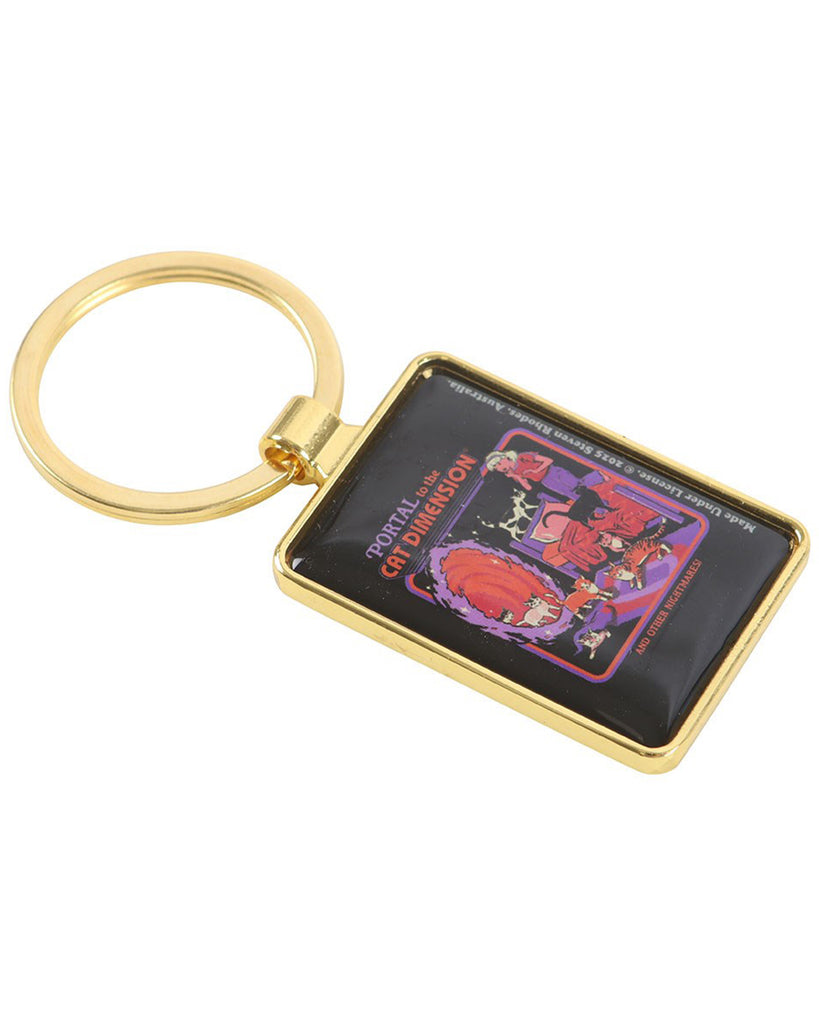 Gold-framed enamel keyring from Rebel Romance with Steven Rhodes’ ‘Cat Dimension’ artwork. The angled view highlights the colourful retro illustration of cats escaping through a glowing portal. A bold, humorous accessory perfect for millennials who love cats and alternative gifts.