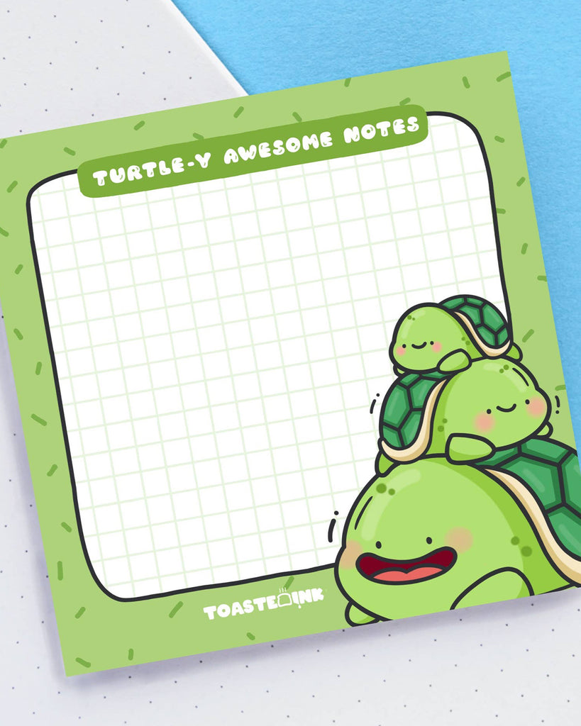 Cute green sticky note pad featuring a kawaii turtle stack illustration by Toastedink, with the phrase “Turtle-y Awesome Notes” at the top. The pad has a green grid and fun sprinkle-style border, sold by Rebel Romance, a small UK business embracing quirky stationery and alternative gifts.