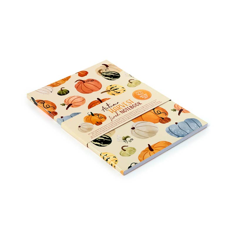 Angled view of the Autumn Harvest Notepad by Rebel Romance, shown with its branded paper bellyband. The pumpkin-themed cover design pops with warm autumnal colours, and the notepad is made from eco-friendly recycled paper.