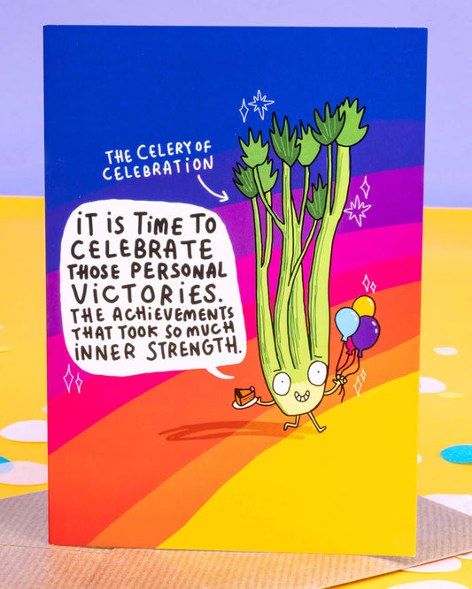 A colourful A6 greeting card from Rebel Romance featuring a cheerful illustrated celery character holding balloons and cake. The card reads, “It is time to celebrate those personal victories. The achievements that took so much inner strength.” Designed by Katie Abey. Ideal for celebrating quiet wins and mental health milestones with a quirky, empowering message.