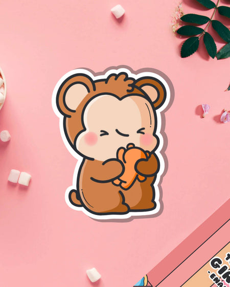Sweet monkey hugging teddy bear vinyl sticker from Toastedink, styled on a pink background with mini marshmallows and leaves. Stocked by Rebel Romance, a UK brand for millennials who love cute, quirky, and unusual designs.