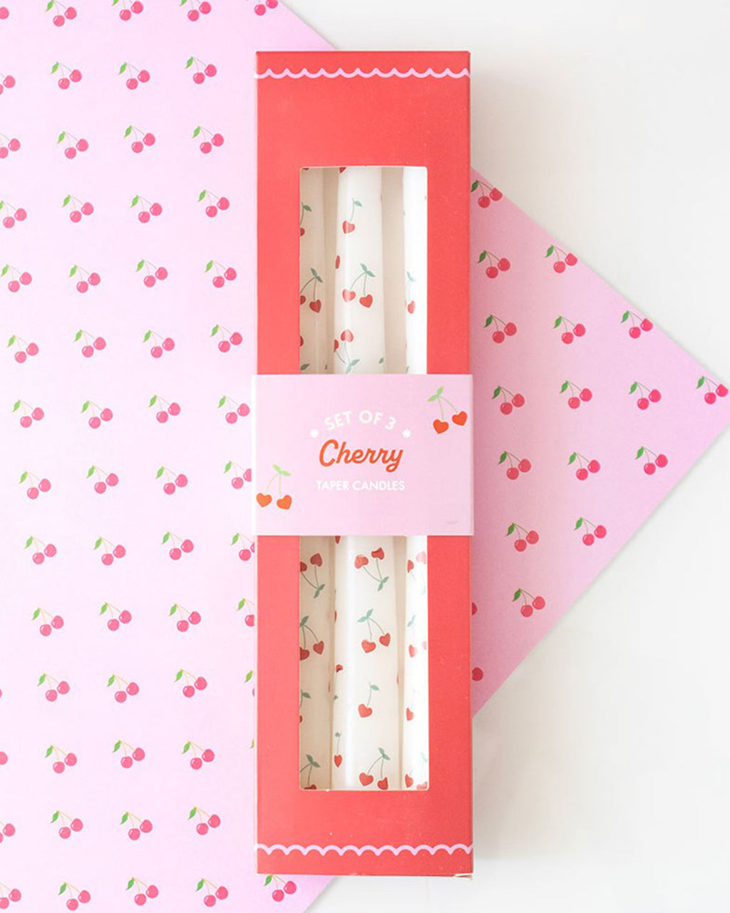 Flat lay of the Rebel Romance Lovestruck collection, featuring the Heart Cherry Taper Candles alongside other Valentine's-themed homeware and gifts. The collection’s retro-inspired design and bold pink and red tones create a fun, romantic vibe.