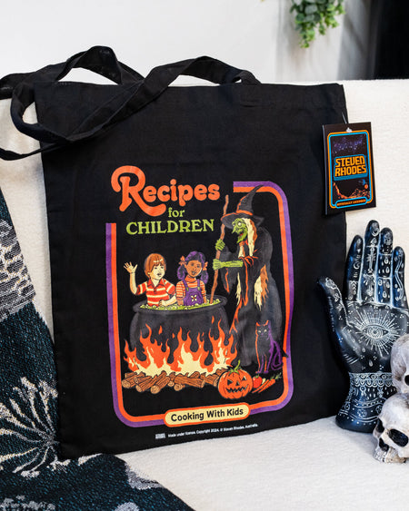 Close-up view of the “Recipes for Children” black tote bag showcasing its vibrant illustration and playful, dark humour design, lying flat for detail display.