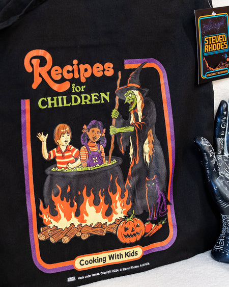 Close-up view of the “Recipes for Children” black tote bag showcasing its vibrant illustration and playful, dark humour design, lying flat for detail display.