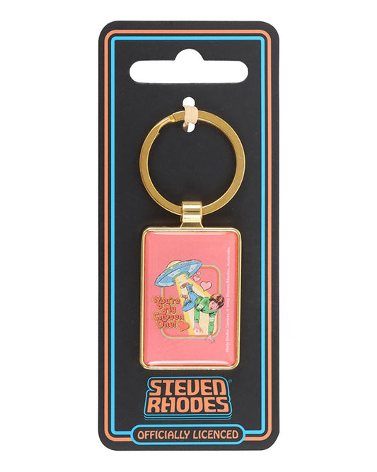 Steven Rhodes “You’re My Chosen One!” keyring on official branded backing card, sold by Rebel Romance. Retro pink enamel design with UFO and hearts, framed in gold. A unique and playful gift for fans of kitsch, alternative, and vintage-style accessories.