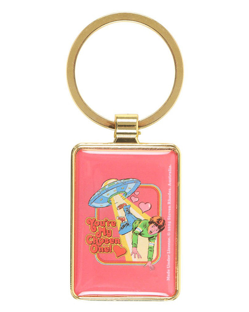 Rebel Romance Steven Rhodes “You’re My Chosen One!” rectangular keyring shown flat. Features a gold frame and ring with a pink enamel design of a UFO abducting a child in retro comic style. A fun novelty gift for alternative fashion and quirky accessory lovers.