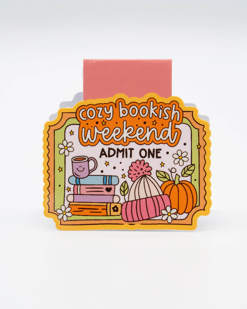 Front view of the Cozy Bookish Weekend Magnetic Bookmark from Rebel Romance, shaped like a colourful ticket with illustrations of books, a smiling mug, a pumpkin, and flowers. Features the words “Cozy Bookish Weekend – Admit One.” Ideal for readers, autumn lovers, and fans of adorable, alternative stationery. A fun and functional gift for millennials who love to get snug with a good book.