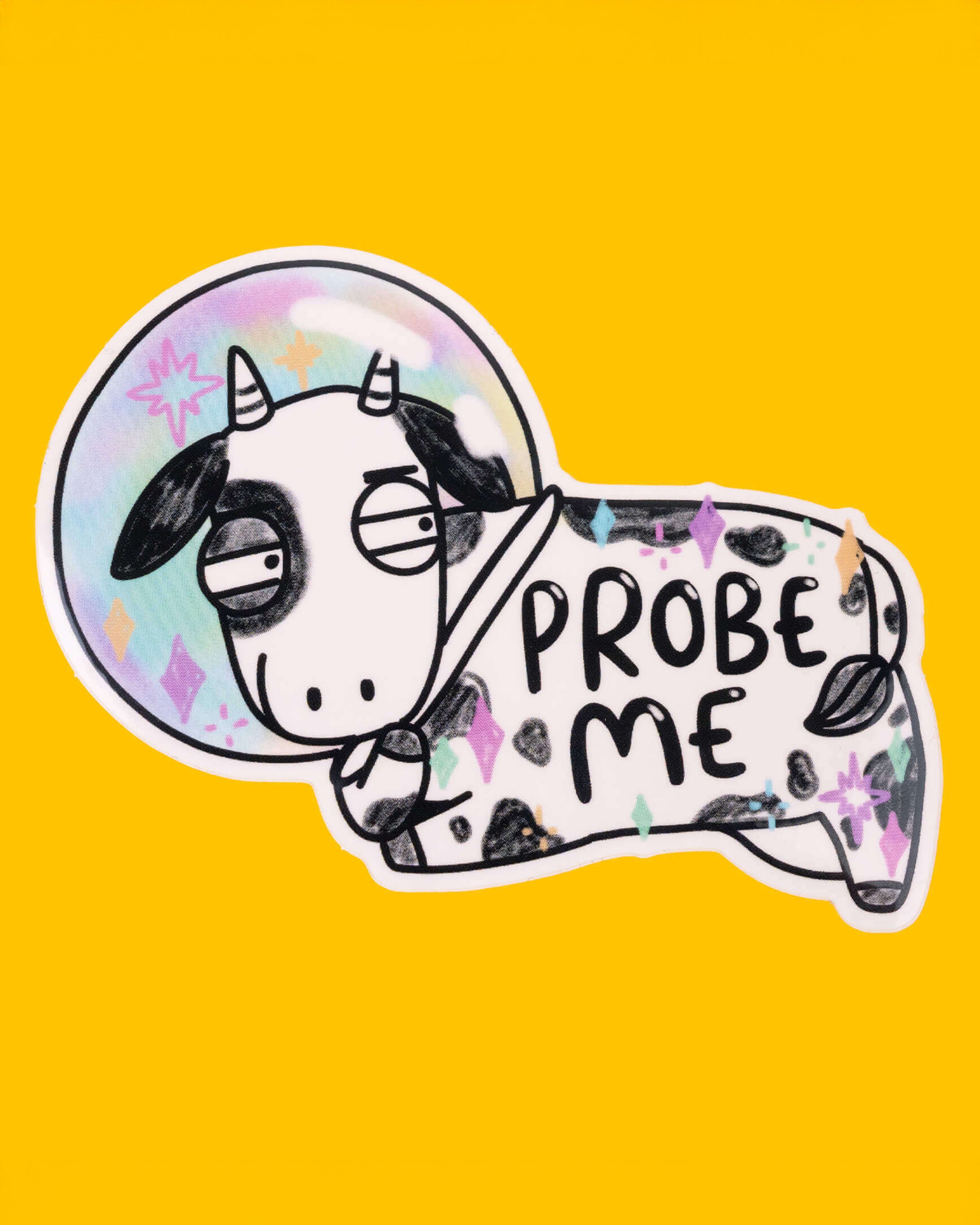 A silly sticker of a black and white cow in a rainbow-coloured space helmet, with the text 