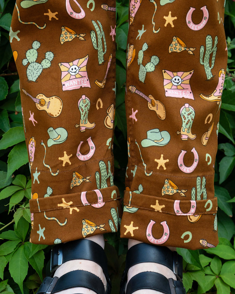 Hem detail of Rebel Romance x Yasmin Cousins Cowboy Stretch Dungarees with matching roll-up cuffs and playful western cowboy print.