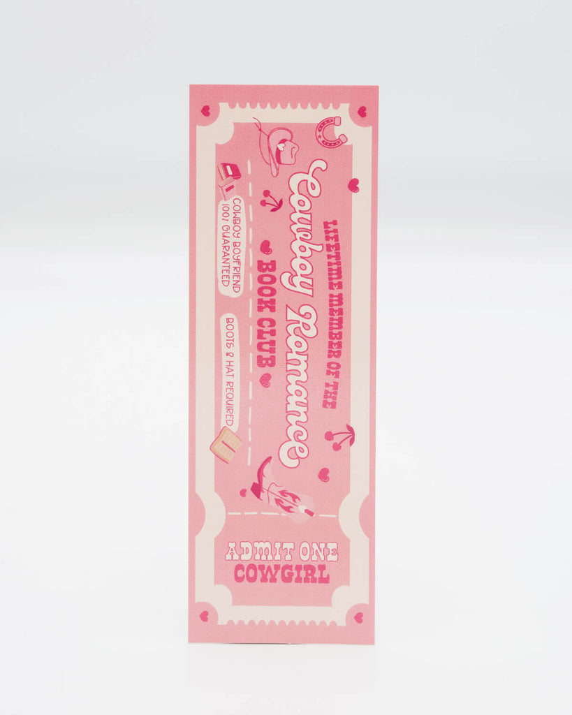 Front view of the Cowboy Romance Book Club Bookmark by Rebel Romance, designed to look like a retro pink ticket. Includes phrases like “Lifetime Member,” “Cowboy Boyfriend 100% Guaranteed,” and “Admit One Cowgirl.” Perfect for fans of spicy cowboy fiction and readers who love playful, themed bookish accessories.