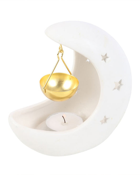 Rebel Romance white crescent moon oil burner with a tealight candle placed at the base and a gold hanging bowl ready for essential or fragrance oils. Perfect witchy and celestial home décor.