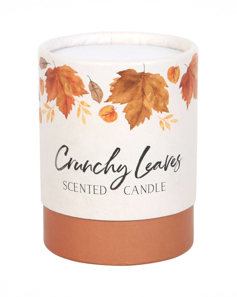 The Rebel Romance Crunchy Leaves candle in its cylindrical cardboard packaging. The design features golden autumn leaves with an elegant script, making it a beautiful gift-ready option for autumn lovers.
