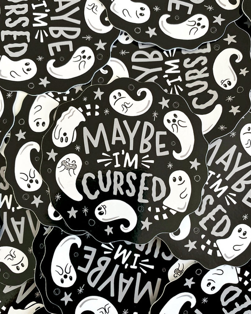 A stack of black vinyl stickers stocked at Rebel Romance with scalloped edges and a playful design. The white text reads "Maybe I'm Cursed" and is surrounded by cute illustrated ghosts, stars, and sparkles. Designed by Yasmin Cousins, the stickers have a gothic and whimsical vibe, perfect for alternative aesthetics.