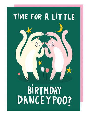A dark green birthday card featuring two dancing cats, one cream and one pink, surrounded by stars, tulips, and a crescent moon. The words “TIME FOR A LITTLE BIRTHDAY DANCEYPOO?” are written in bold white letters. A pink envelope is included.