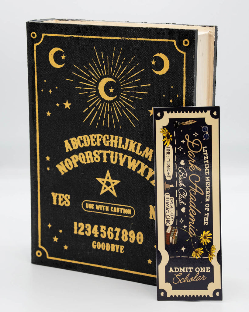 Cream and black ticket-shaped bookmark featuring the text “Lifetime Member of the Dark Academia Book Club – Admit One Scholar.” Includes gothic motifs like books, stars, yellow florals, and handwritten script. A must-have for bookish lovers of literary chic and midnight reading, designed by Rebel Romance, a small UK brand embracing alternative and millennial aesthetics.