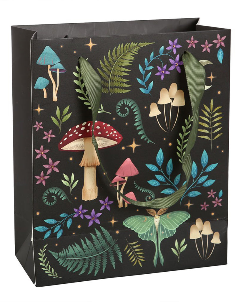 Rebel Romance Medium Dark Forest Print Gift Bag with green ribbon handles, decorated with enchanted forest artwork featuring mushrooms, ferns, bright leaves, purple flowers, stars and a luna moth, designed to add a touch of whimsy to your gifting.