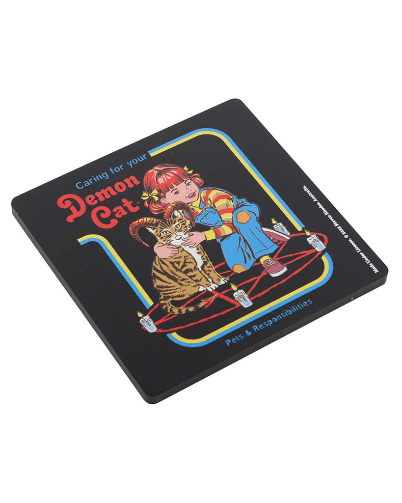 Angled view of the Caring for Your Demon Cat Steven Rhodes coaster from Rebel Romance. Retro-style artwork with a girl and her demon cat surrounded by candles on a pentagram. Funny gothic homeware gift.