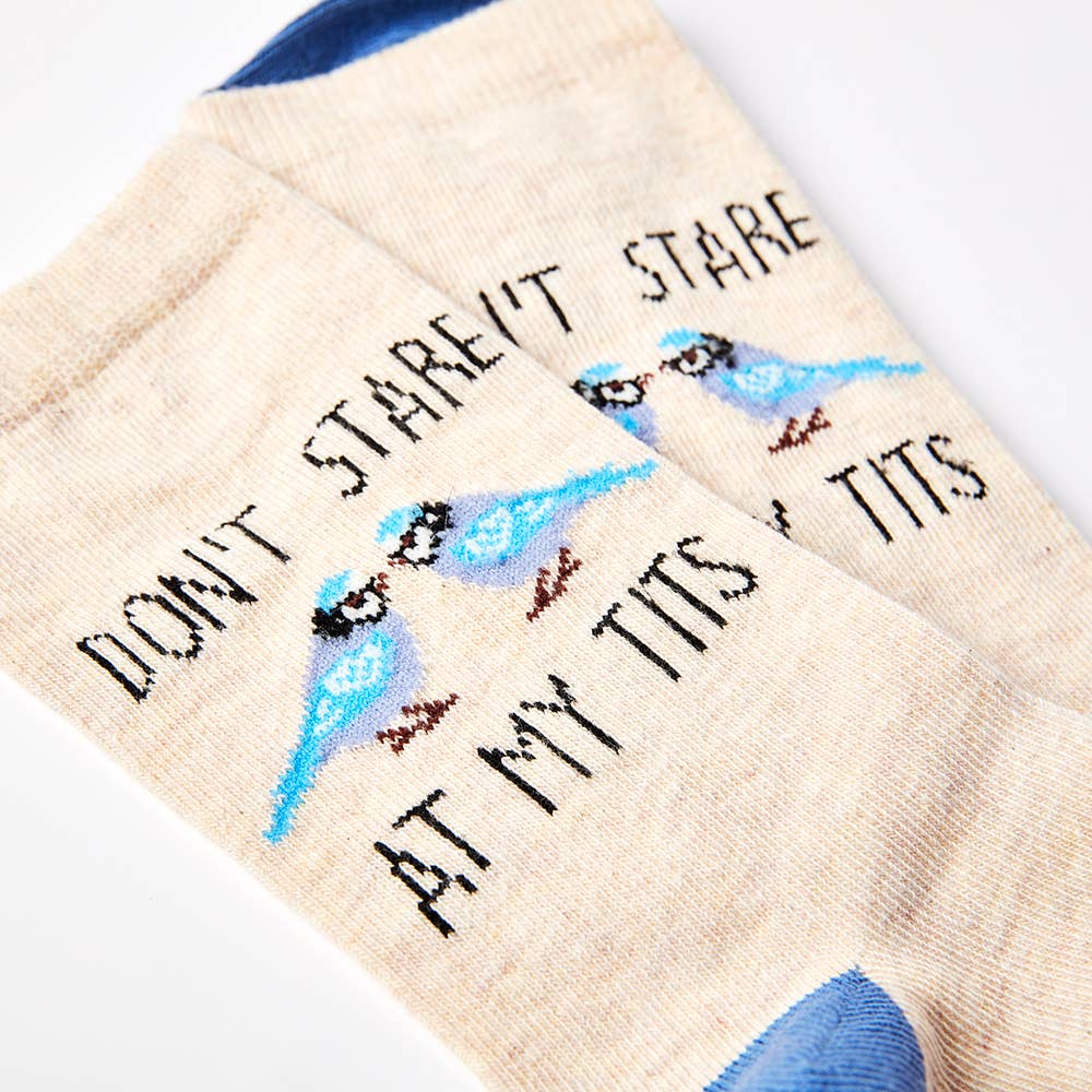 Close-up of Urban Eccentric beige socks featuring two blue tit birds and the cheeky phrase “Don’t Stare at My Tits.” Fun novelty socks sold by Rebel Romance.
