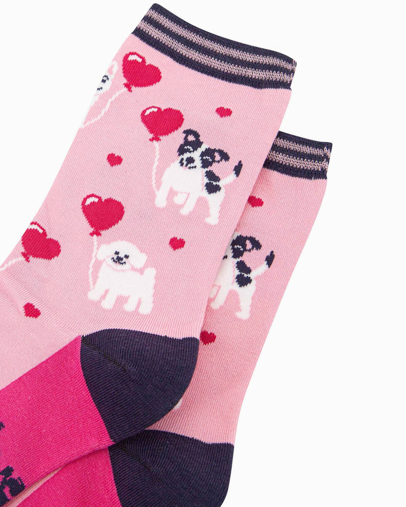 (Close-Up of Design): A close-up of the pink bamboo socks, capturing the pixelated dog details, heart balloons, and tiny floating hearts on the fabric.
