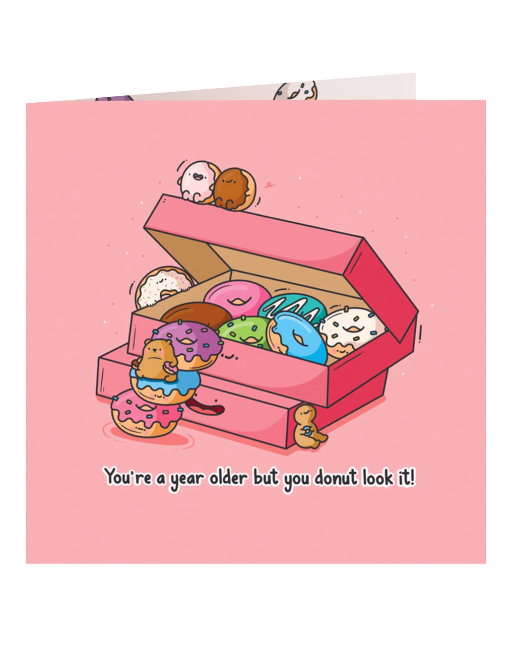 Front cover of the Toastedink birthday card featuring a pink box of colourful cartoon donuts with smiling faces and a bear climbing the donuts, with the caption 
