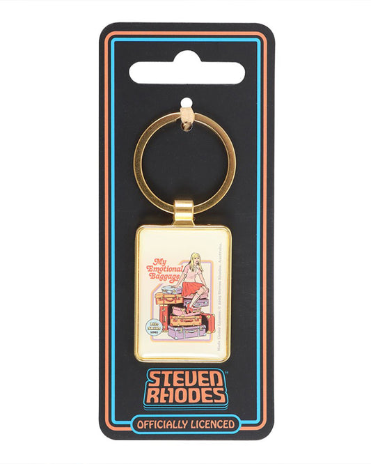 “My Emotional Baggage” enamel keyring by Steven Rhodes displayed on branded backing card from Rebel Romance. The rectangular gold keyring features a retro illustration of a girl sitting on stacked suitcases. A quirky alternative gift with vintage humour, perfect for millennials.
