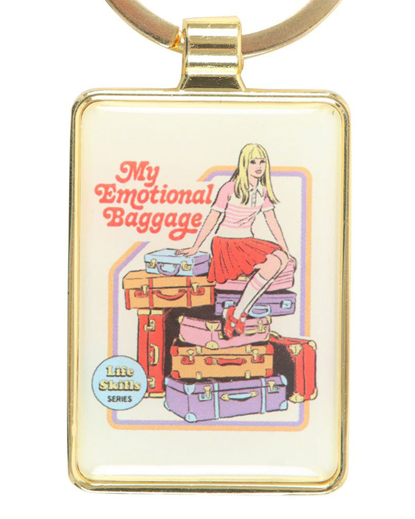 Rectangular enamel keyring with a gold frame from Rebel Romance, featuring Steven Rhodes’ retro artwork of a blonde girl sitting on colourful stacked suitcases with the text “My Emotional Baggage.” A quirky alternative accessory, perfect for millennials who love unique gifts, retro humour, and bold style.