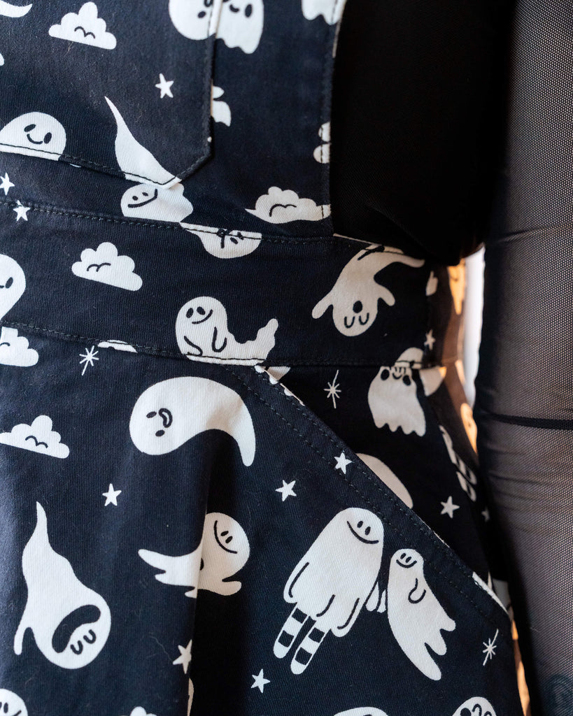 Super close up of the ghosties print by yasmin cousins on a flared pinafore dress from Rebel Romance shown on a femme model. 