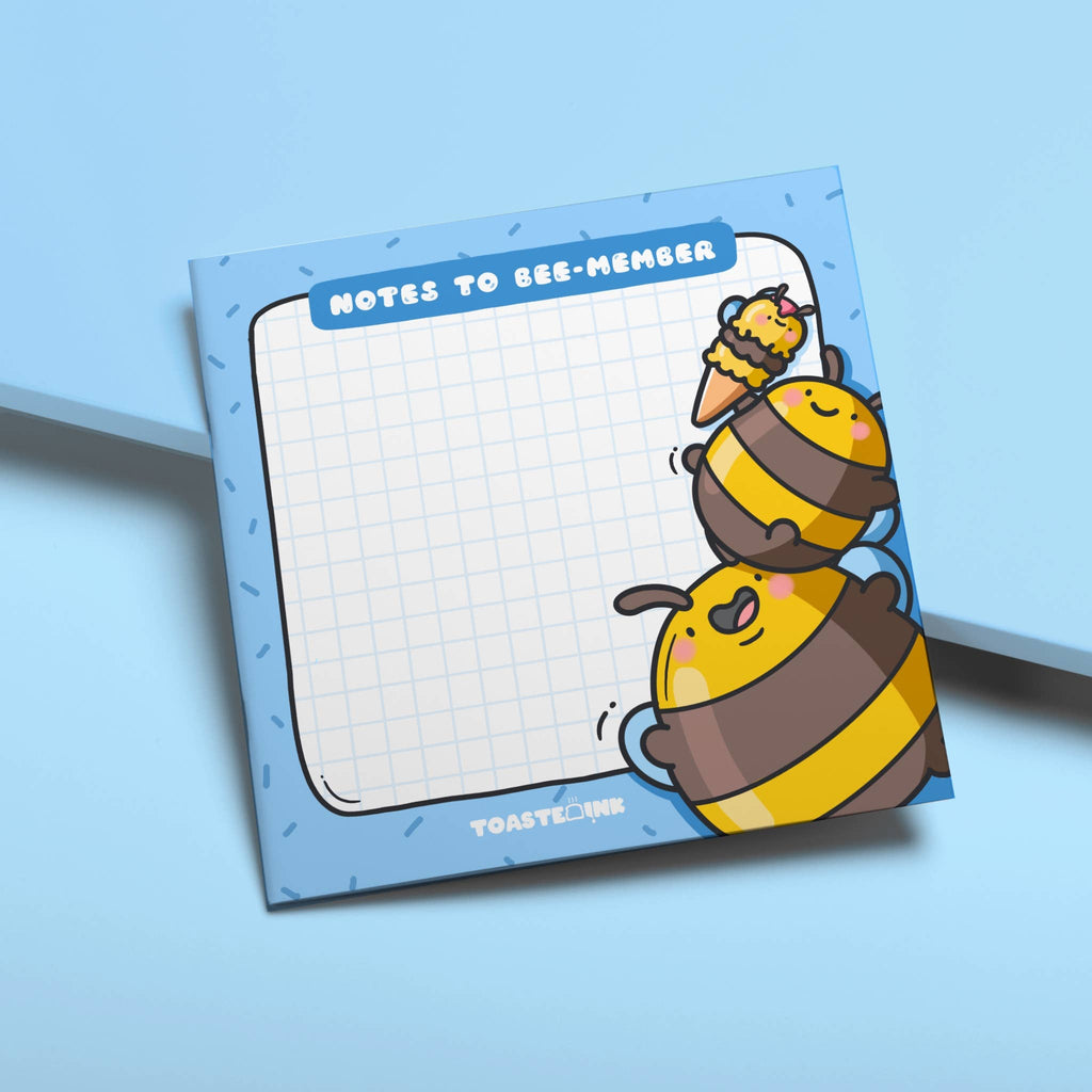 Square sticky note pad with a blue border and grid paper, featuring two chubby yellow and brown cartoon bumble bees stacking on top of each other to reach an ice cream. The top reads “Notes to Bee-member” in bold white text. Cute and practical stationery for daily reminders.