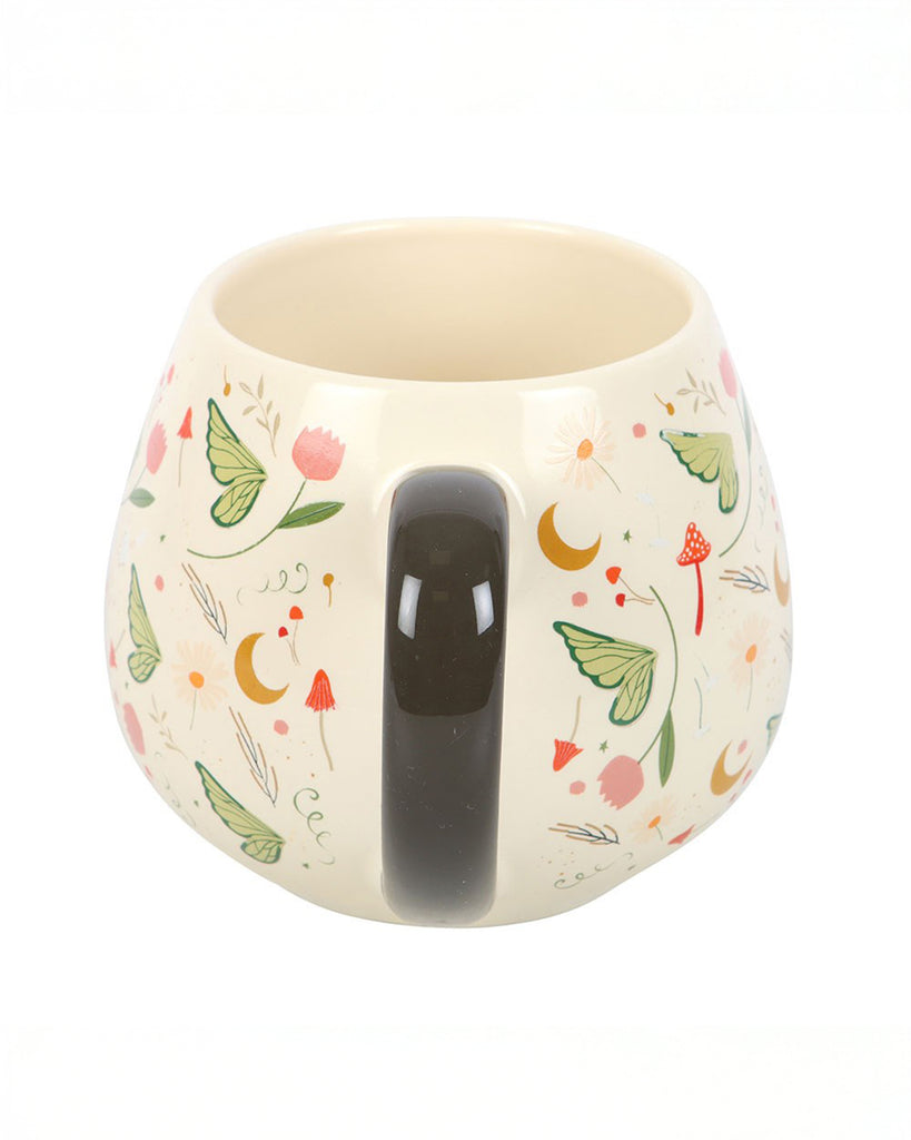 Back view of the Rebel Romance Fairy Folklore Print Rounded Mug, showing its dark curved handle and whimsical print of flowers, mushrooms, butterflies and crescent moons. A dreamy fairycore design perfect for gifting and everyday use, from a UK brand celebrating alternative style.
