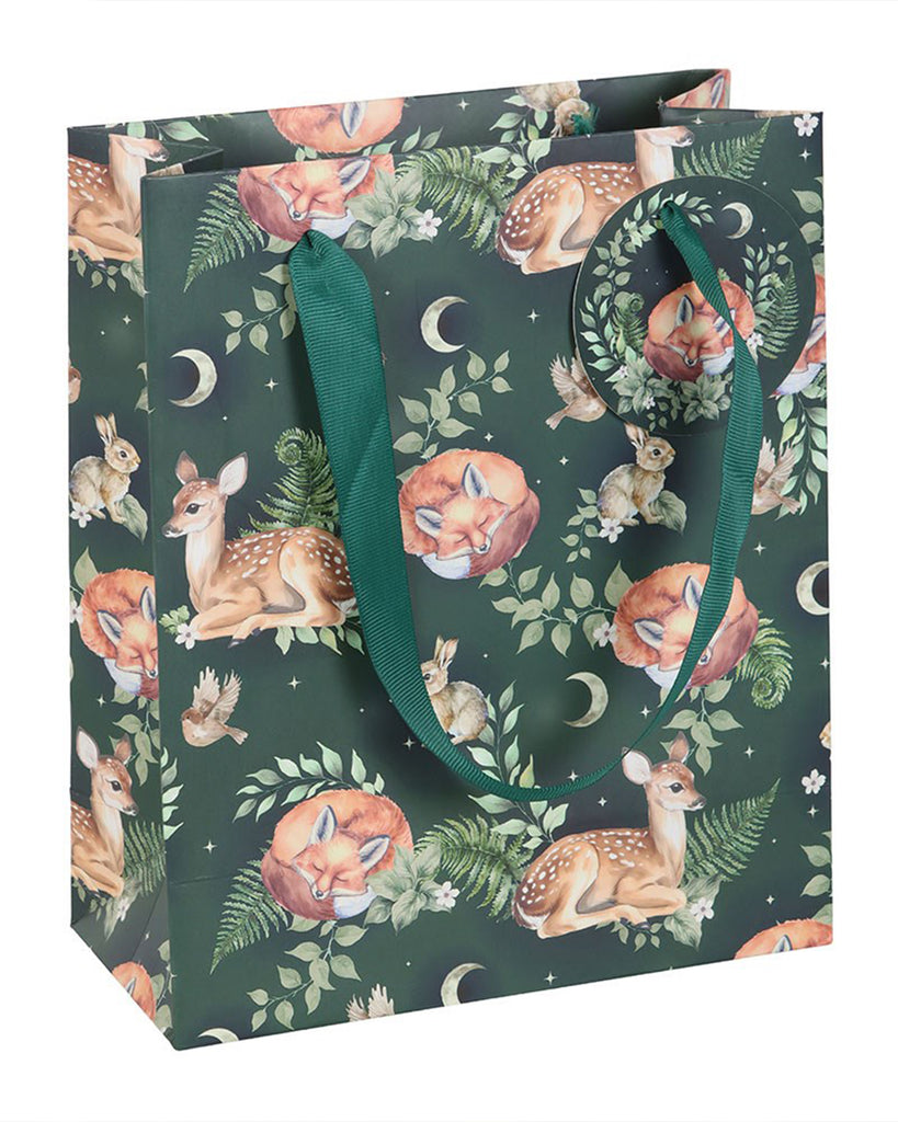A 23cm Rebel Romance forest print gift bag covered in foxes, fawns, rabbits and moon motifs, with matching green ribbon handles and a round illustrated tag, ideal for eco‑friendly gifting.