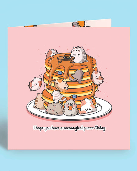 Close-up of a square pink birthday card with cute illustrated cats on a pancake stack and the pun “I hope you have a meow-gical purrr-thday.” Ideal for cat lovers. Designed by Toastedink and stocked by Rebel Romance, a UK brand for quirky, nostalgic gifts.