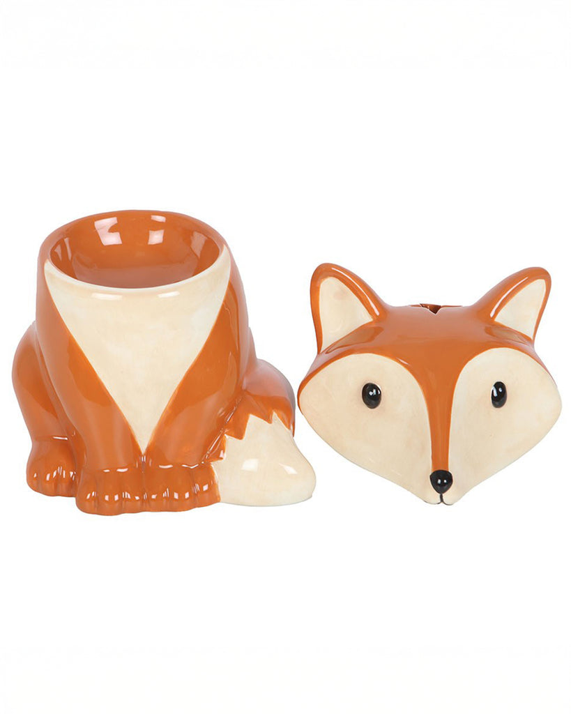 Fox-shaped oil burner and wax warmer shown with the lid removed. The ceramic fox is hollow inside to hold a tealight, with the head piece placed beside it. Designed by Rebel Romance in a glossy orange and cream woodland animal style.