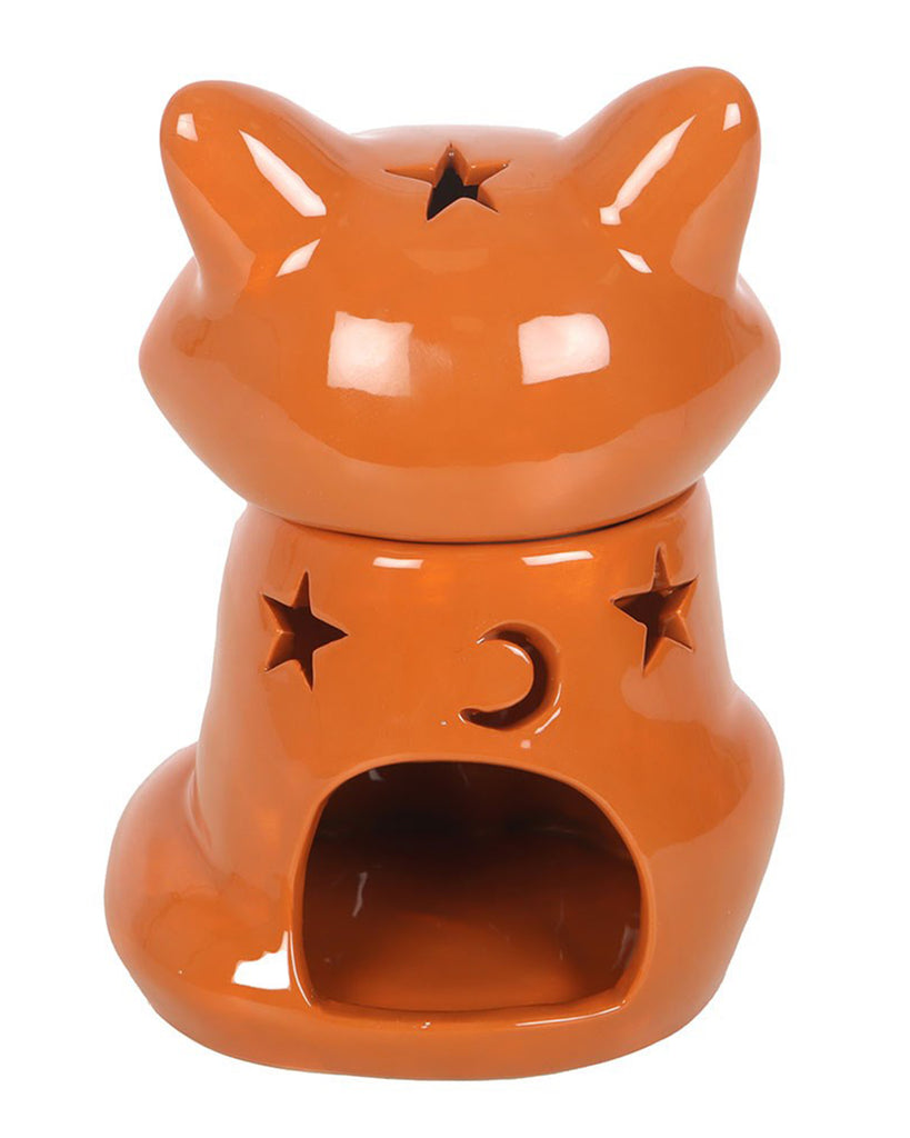 Back view of the Rebel Romance fox oil burner and wax warmer in burnt orange ceramic. The fox’s back features cut-out star and moon shapes to let light shine through when a tealight is lit inside. The lid, shaped like a fox's head, has a star cut-out on top.