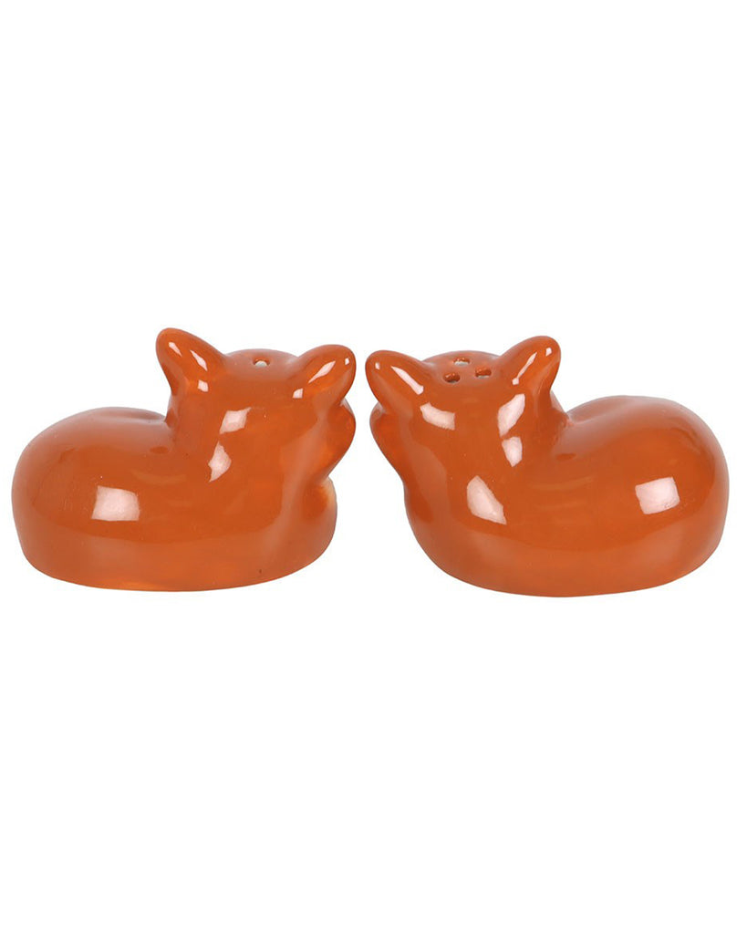 Rear view of two ceramic fox-shaped salt and pepper shakers, showing their smooth orange backs and the placement of shaker holes.