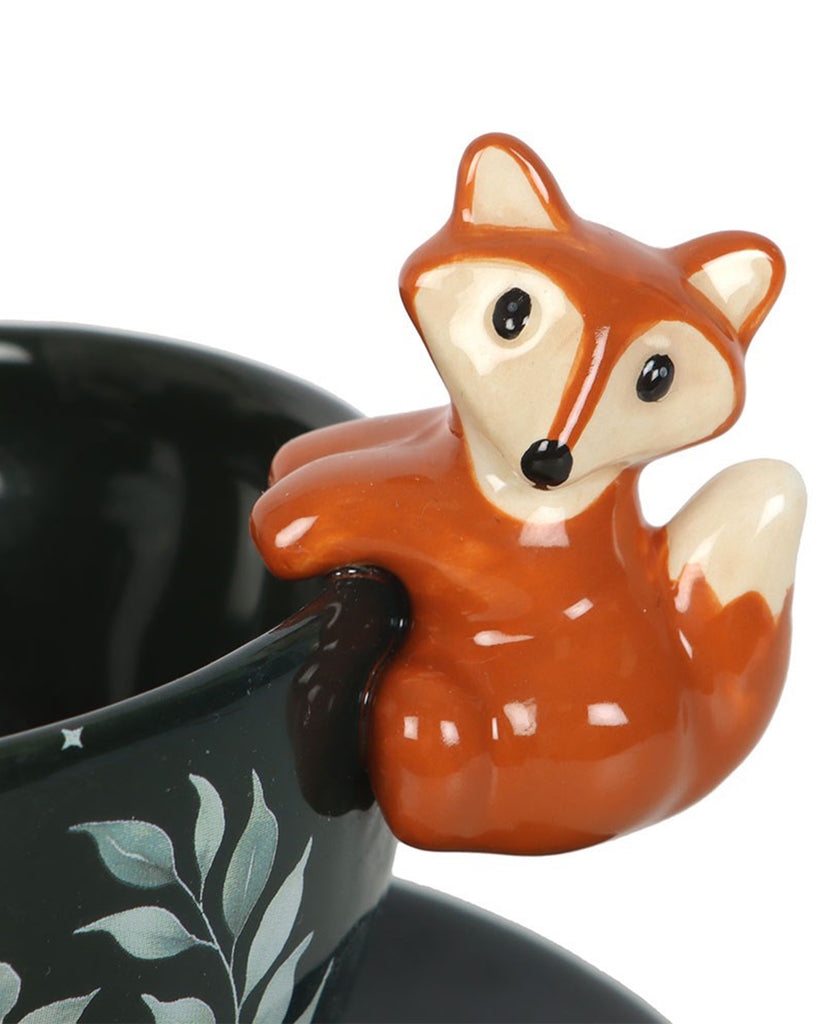 Detailed view of the 3D ceramic fox on the Rebel Romance forest teacup handle. The fox clings playfully to the rim, adding a charming woodland twist to your tea break.