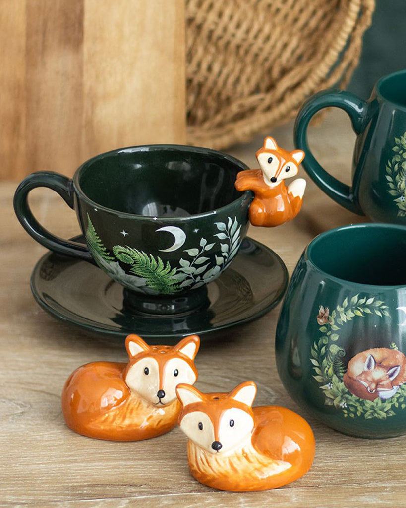 Green forest teacup with saucer and 3D fox handle by Rebel Romance, displayed on a wooden table with forest-themed mugs and ceramic fox salt and pepper shakers. A whimsical gift idea for fox lovers and nature enthusiasts.