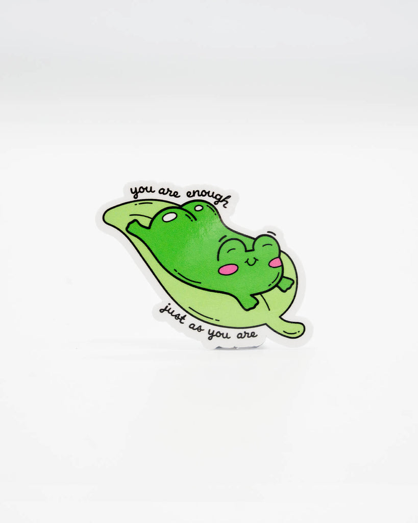 Cute die-cut vinyl sticker featuring a happy green frog lounging on a lily pad with the uplifting phrase “You are enough just as you are.” A sweet, motivational design perfect for laptops, journals, and self-love reminders. Created by Rebel Romance, a small UK brand that champions alternative style, quirky gifts, and feel-good millennial aesthetics.