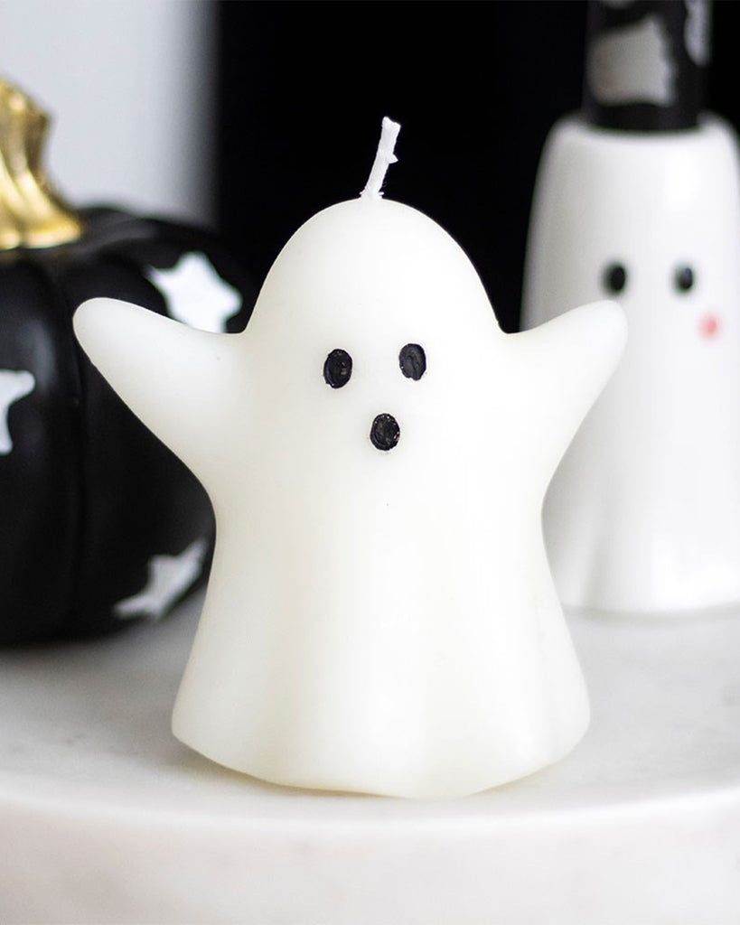 Close-up of the Sweet Ghost Shaped Candle displayed on a marble tray next to Halloween decorations. A fun and whimsical candle perfect for spooky season styling and alternative gifting.