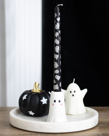 Halloween home styling with the Rebel Romance Sweet Ghost Candle Holder and ghost-printed taper candle on a round white tray. Styled with a black pumpkin with white stars and a mini ghost candle for a spooky-chic look.