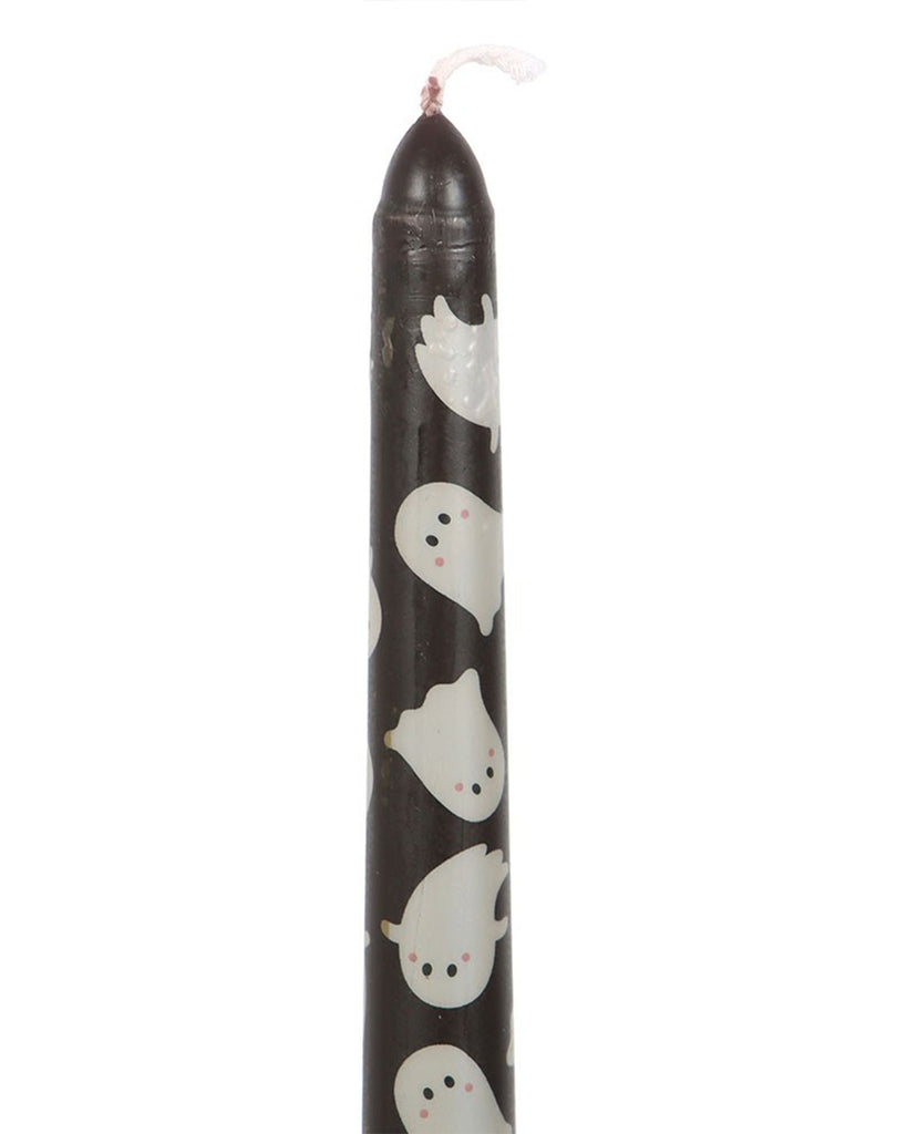 Close-up of the taper candle from Rebel Romance, showing the white ghost print details on the black wax. The ghosts have small black eyes and pink cheeks, adding a whimsical Halloween touch.