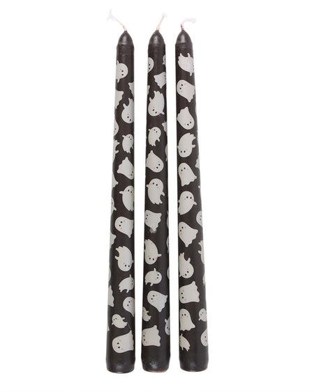 Set of three ghost print taper candles by Rebel Romance displayed side by side. The unscented black candles are decorated with a repeat pattern of cheerful white ghosts, ideal for adding a fun and festive touch to Halloween dinner parties or alternative home styling.
