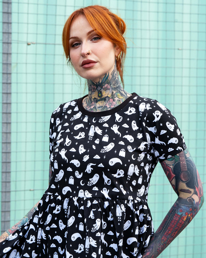 Close-up of Erin wearing the Rebel Romance Ghosties Smock Dress. The black stretch cotton fabric features white cartoon ghost prints with stars and moons, highlighting the round neckline and short sleeves.