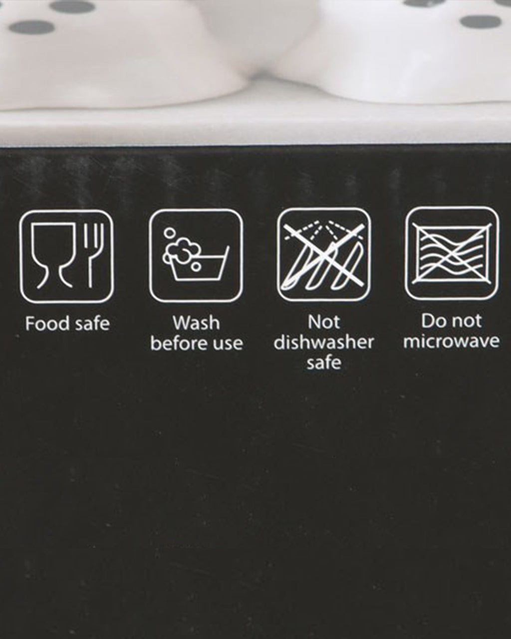 A close-up of the Ghost Salt & Pepper Shaker Set’s packaging from Rebel Romance, displaying care instructions. The box highlights that the shakers are food-safe, should be washed before use, and are not suitable for the microwave or dishwasher.