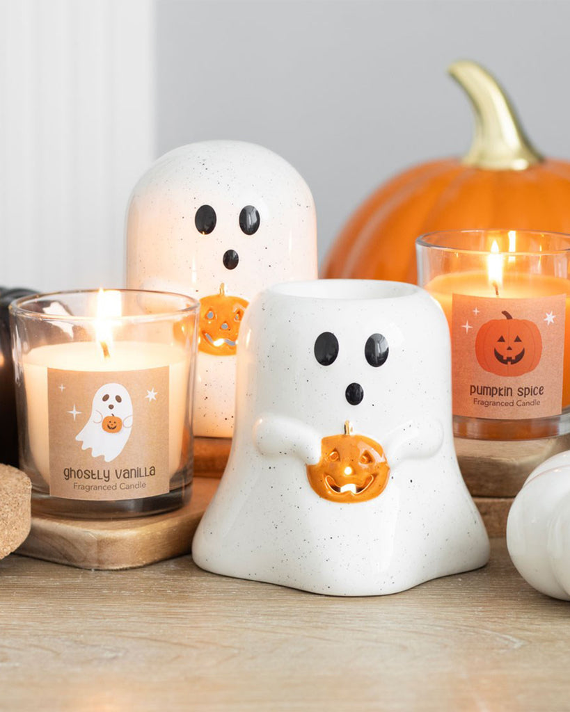 Halloween-themed ghost tealight holders with pumpkins, styled alongside pumpkin spice and vanilla candles on a rustic table. Designed by Rebel Romance, these ceramic ghost candle holders add a spooky-cute glow to your gothic or autumn home décor.