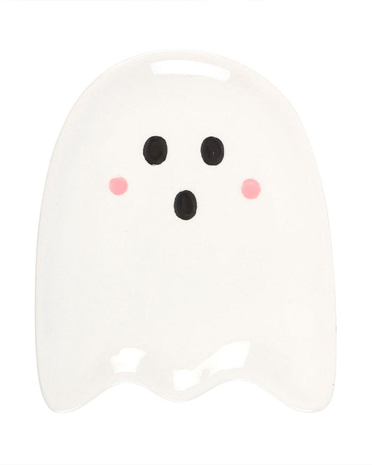Overhead view of the Sweet Ghost Ceramic Dish by Rebel Romance. The ceramic dish is shaped like a cute ghost with rounded edges, two black eyes, a black mouth, and pink blush cheeks. Ideal for holding rings or trinkets, this alternative home accessory is perfect for Halloween or gothic décor.