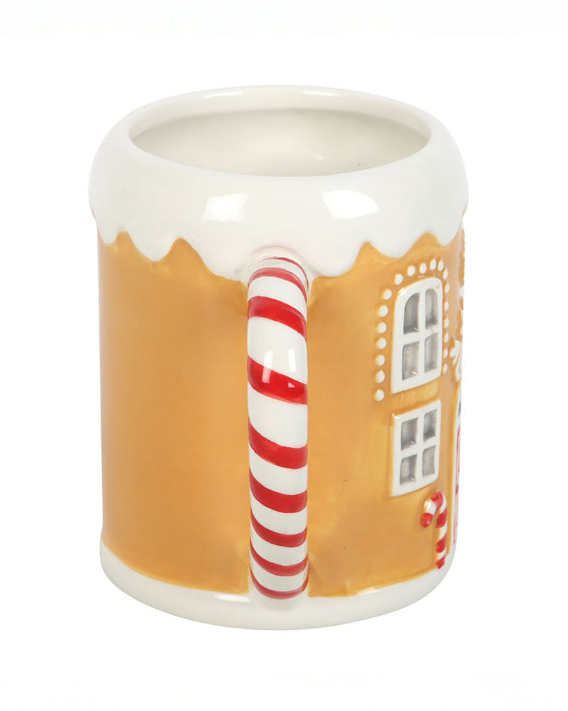 Side view of the Rebel Romance Candy Cane Gingerbread House Mug, showing the curved red and white candy cane handle and part of the textured gingerbread-style body with window details. A quirky Christmas mug for tea, coffee or hot chocolate.