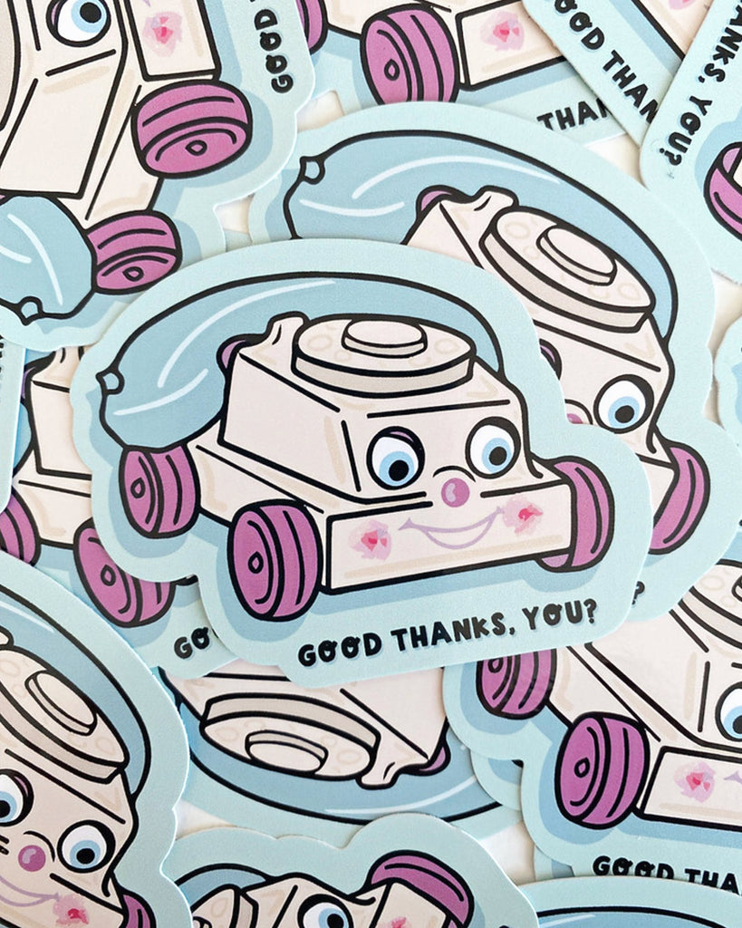 A pile of “Creepy Phone” stickers with a retro toy telephone design stocked at Rebel Romance. The sticker features a smiling, slightly creepy cartoon phone in pastel shades with purple wheels and a blue cord. The text reads “GOOD THANKS, YOU?” and the illustration is by Yasmin Cousins.